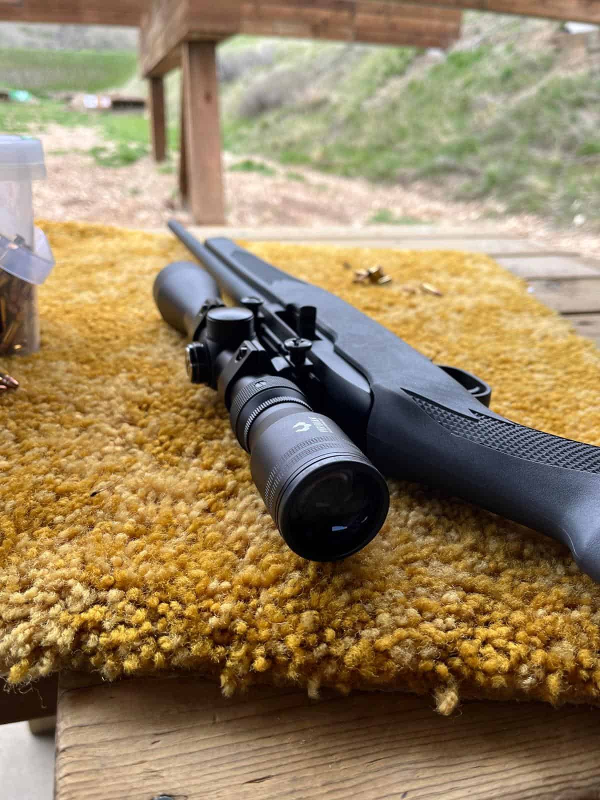 A .22 rifle laying on a bench at the gun range.