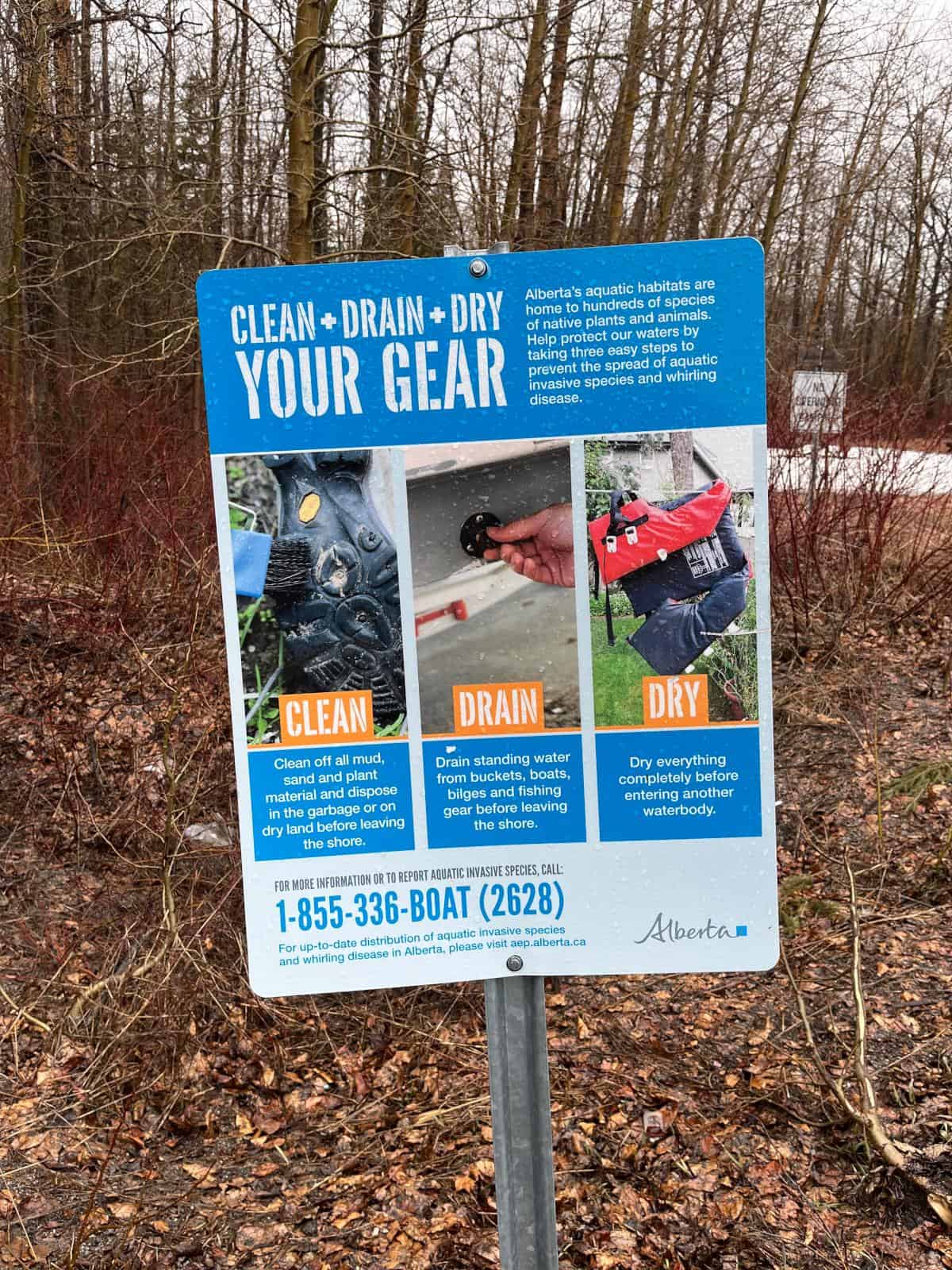 A sign on the edge of a lake that explains how to clean, drain, dry your gear.