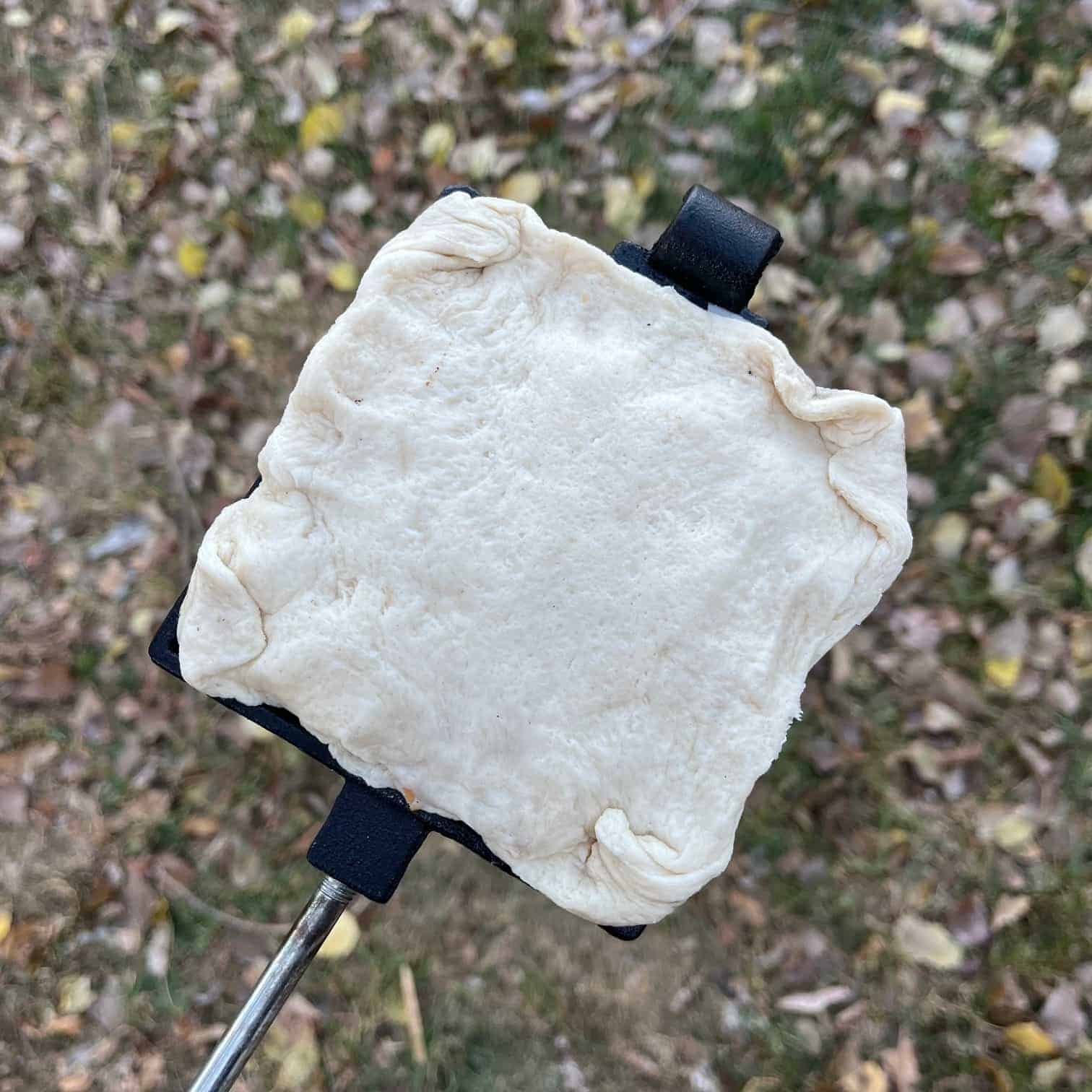 An uncooked pie iron pizza pocket ready for the fire.